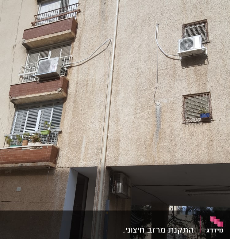 בניין עם מרפסות ומזגנים על הקיר החיצוני